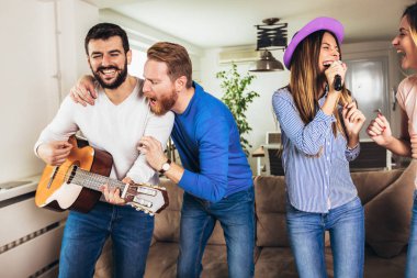 Evde karaoke yapan bir grup arkadaş. Arkadaşlık kavramı, ev eğlencesi ve insanlar