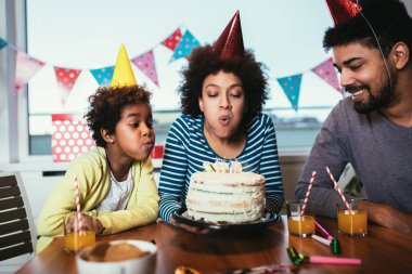 Mutlu bir aile evde doğum gününü kutluyor. 
