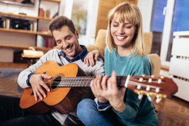 Romantik Çift gitar çalmak adama eğlenceli evimde