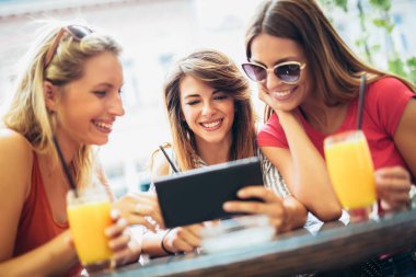 Üç güzel arkadaş bir kafe kullanarak tablet pc ve having fun