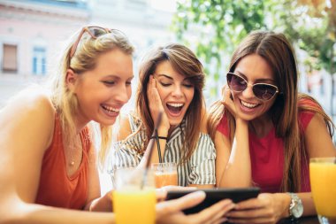 Üç güzel arkadaş bir kafe kullanarak tablet pc ve having fun