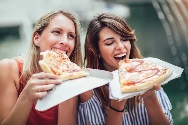 İki güzel genç kadın birlikte eğleniyor alışveriş sonra pizza yemek.