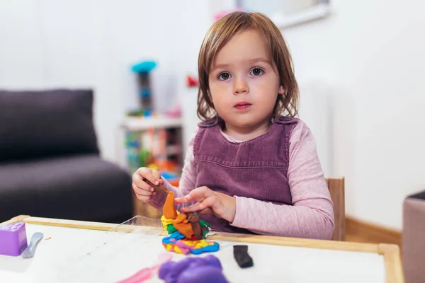 Niña Está Jugando Con Plastilina Mientras Está Sentado Mesa Habitación —  Fotos de Stock