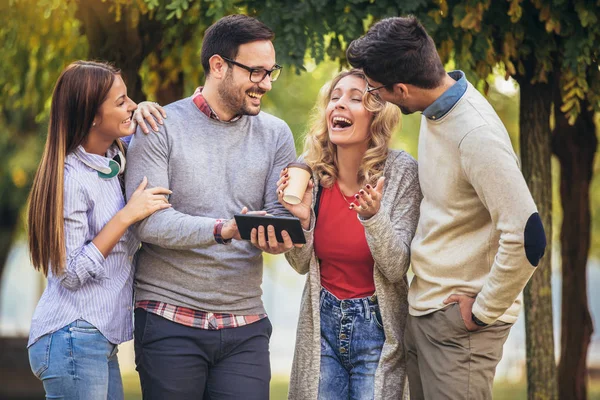 Quatro Felizes Jovens Amigos Sorridentes Andando Livre Parque Segurando Tablet — Fotografia de Stock