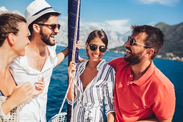 Lächelnde Freunde, die auf einer Yacht segeln - Urlaub, Reise, Meer, Freund — Stockfoto