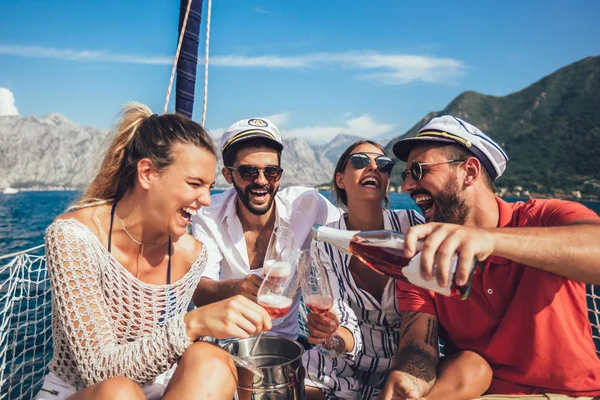 Lachende vrienden met glazen champagne op jacht. Vakantie, tr — Stockfoto