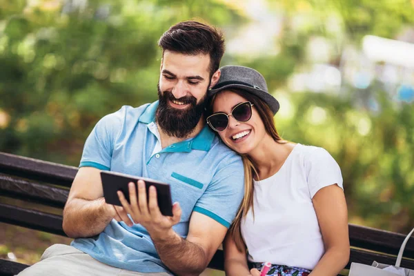Junges attraktives Paar spricht und schaut auf digitales Tablet. — Stockfoto