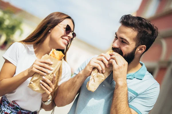 Молода пара їсть бутерброди і чудово проводить час — стокове фото