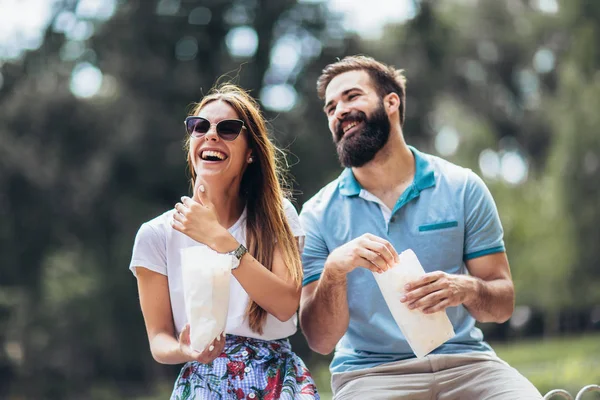 Junges Paar im Park isst an schönem sonnigen Tag Popcorn — Stockfoto