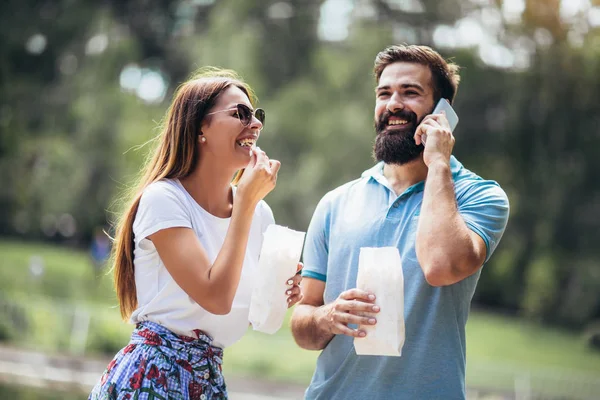 Junges Paar im Park isst an schönem sonnigen Tag Popcorn — Stockfoto