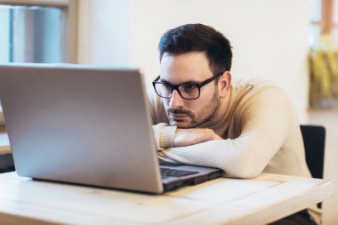 Adam dizüstü bilgisayarda çalışırken vurguladı. Hayal kırıklığına uğramış genç b üzgün