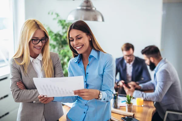 Portret van twee jonge zakenvrouw terwijl collega in pagina — Stockfoto