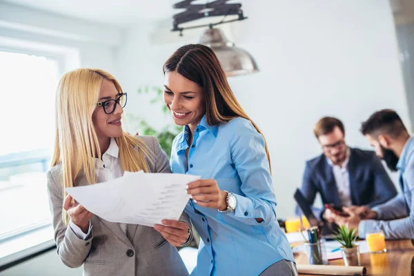 Retrato de dos jóvenes empresarias mientras son compañeras de trabajo — Foto de Stock