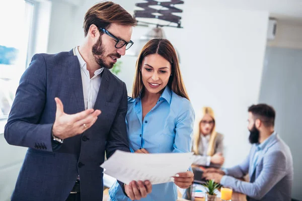 Retrato de dos jóvenes empresarios mientras que colega en el backgrou — Foto de Stock