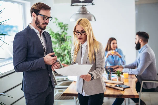 Retrato de dos jóvenes empresarios mientras que colega en el backgrou — Foto de Stock