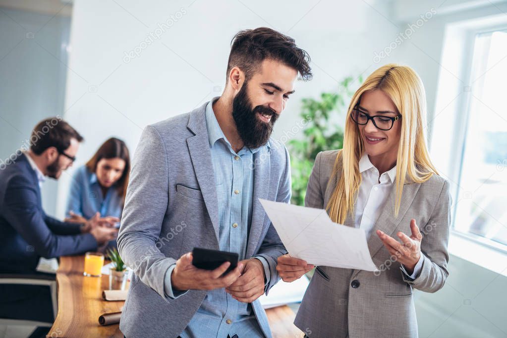 Portrait of two young businesspeople using digital tablet while 