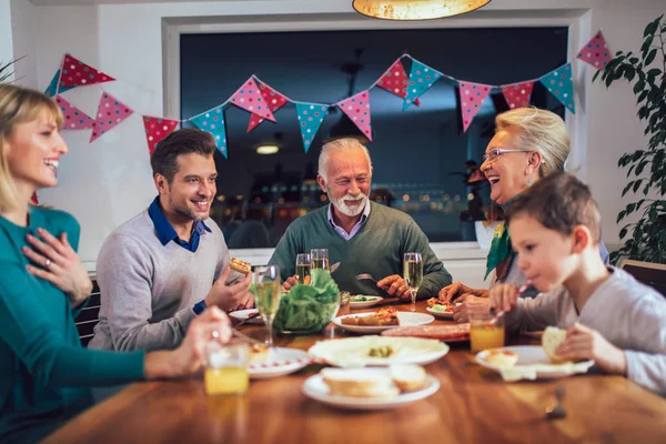 Família da multi geração que aprecia a refeição em torno da mesa em casa — Fotografia de Stock