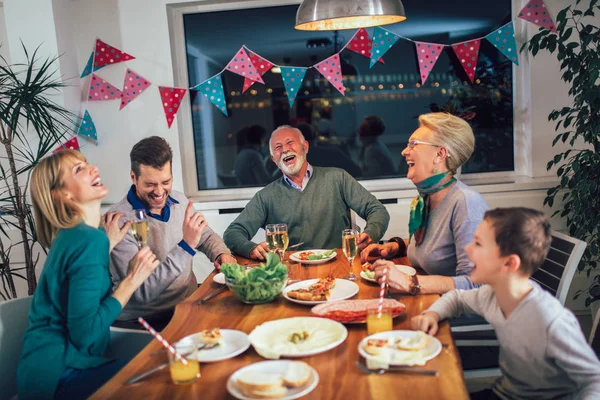 Família da multi geração que aprecia a refeição em torno da mesa em casa — Fotografia de Stock