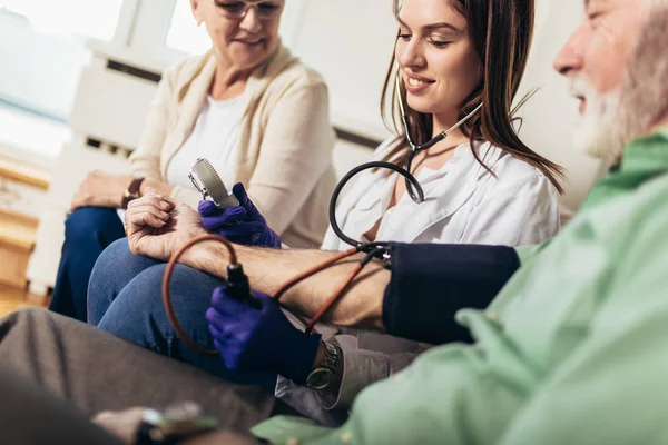 年轻的医生在家访时测量血压 — 图库照片