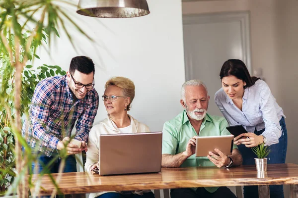 Young volunteers help senior people on the computer. Young peopl — Stock Photo, Image