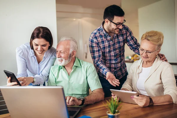 Young volunteers help senior people on the computer. Young peopl