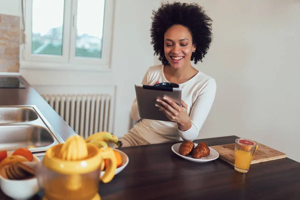 Sorridente giovane donna africana utilizzando tablet digitale in cucina — Foto Stock