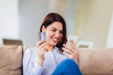 Bir kredi kartı tutan ve akıllı fon kullanarak eller güzel kadın