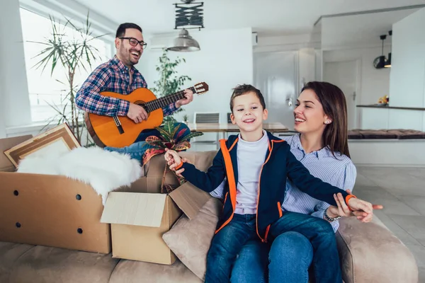 Happy family moving home with boxes around, and having fun. — Stock Photo, Image