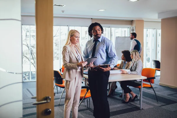 Portrait of two young businesspeople using digital tablet while — Stock Photo, Image