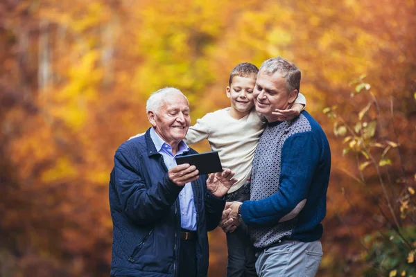 Äldre far vuxen son och sonson ut för en promenad i parken — Stockfoto