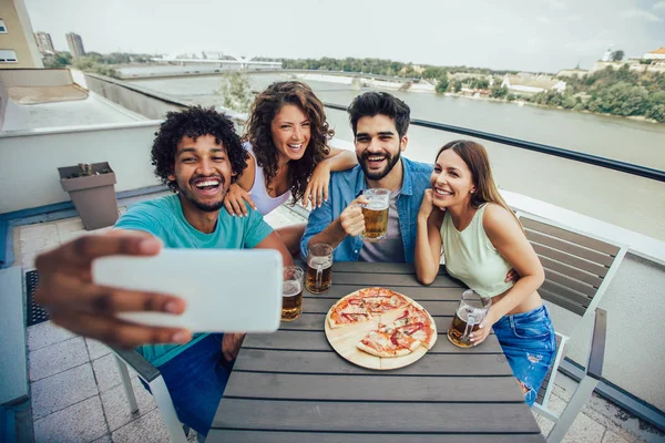 Друзі насолоджуються піцою. Група молодих веселих людей їдять пі — стокове фото
