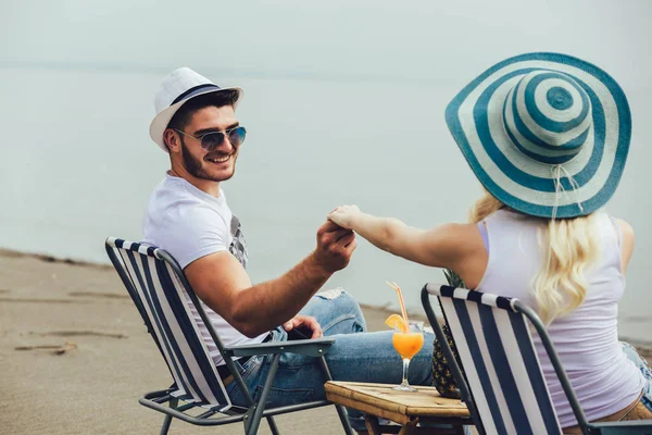 Пара на стільці, що розслабляється на пляжі. Щаслива пара насолоджуйтесь — стокове фото