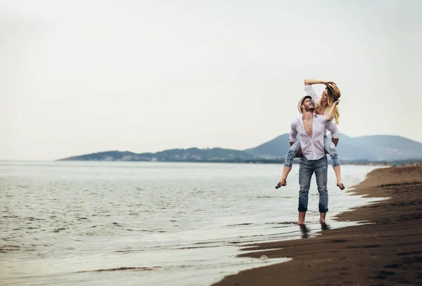 Coppia felice innamorata durante le vacanze estive al mare. Gioioso maialino ragazza — Foto Stock