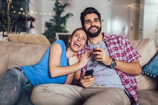 Beau jeune couple regardant la télévision dans le salon . — Photo