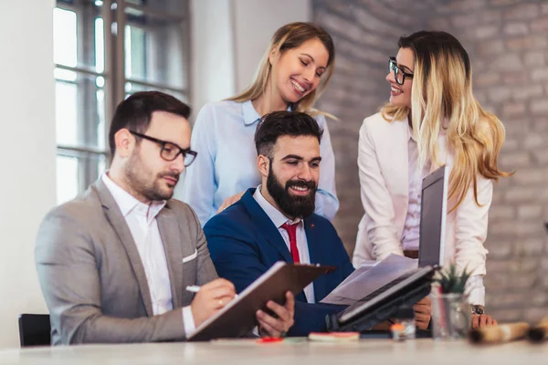 Los colegas de negocios que trabajan en el ordenador portátil en la oficina moderna. — Foto de Stock