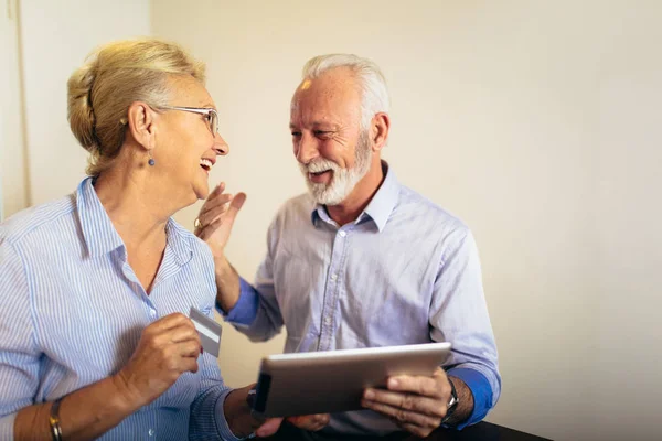 Moderní senior pár online nakupování s tabletem a kreditní karty — Stock fotografie