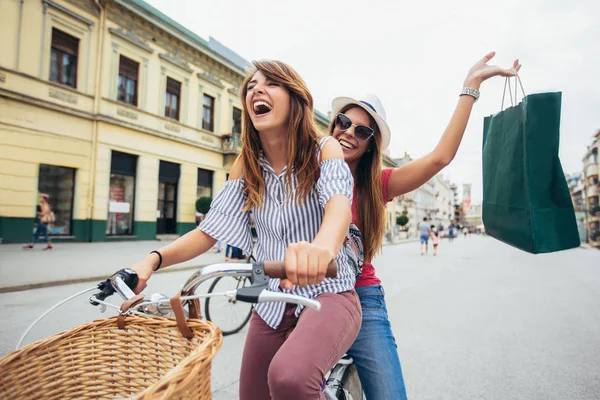 Δύο όμορφες γυναίκες Ψώνια για το ποδήλατο στην πόλη — Φωτογραφία Αρχείου