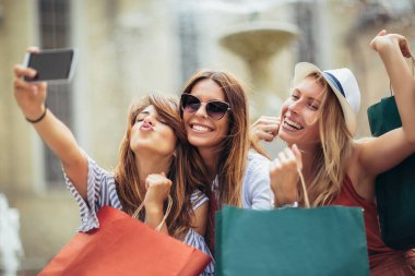 Üç kadın birlikte alışveriş ve selfie fotoğraf yapmak