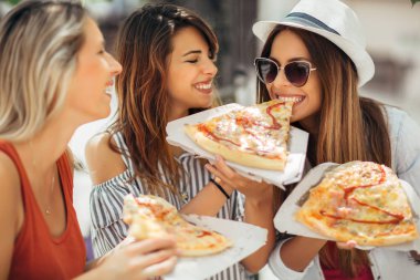 Üç güzel genç kadın alışveriş sonra pizza yemek sahip 