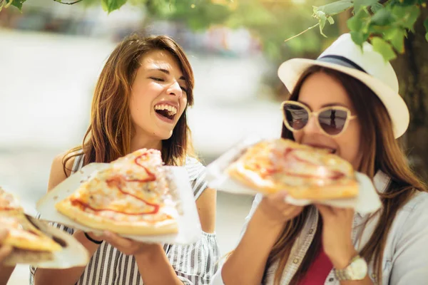 Trois belles jeunes femmes mangeant de la pizza après avoir fait du shopping, ayant — Photo