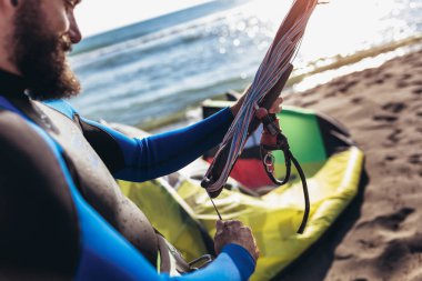 Wetsuits uçurtma donanımları için dalga köpüğü ile adam sufrers.