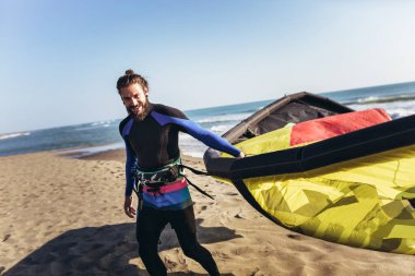 Yakışıklı beyaz adam profesyonel sörfçü sandy üzerinde duran