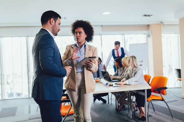 Portrait of two young businesspeople using digital tablet while — Stock Photo, Image