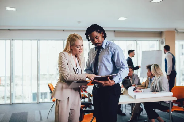 Portrait of two young businesspeople using digital tablet while — Stock Photo, Image