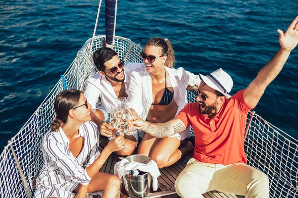 Amigos sonrientes con copas de champán en el yate. Vacaciones, tr —  Fotos de Stock