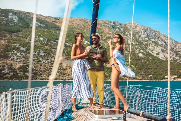 Amigos sonrientes navegando en yate - vacaciones, viajes, mar, amigo —  Fotos de Stock