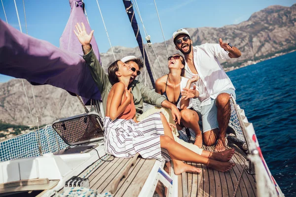 Smilende venner med glas champagne på yacht. Ferie, ferie - Stock-foto
