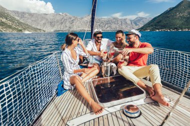 Smiling friends with glasses of champagne on yacht. Vacation, tr clipart