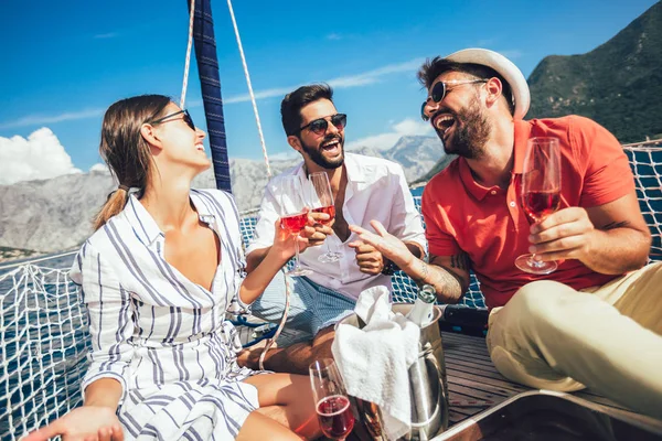 Smiling friends with glasses of champagne on yacht. Vacation, tr — Stock Photo, Image
