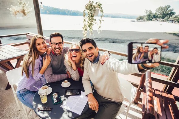 Fröhliche Gruppe von Freunden amüsiert sich im Café, macht Selfie-Foto. — Stockfoto